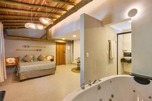 a bathroom with a bed and a bath tub at Hotel Coquille in Ubatuba