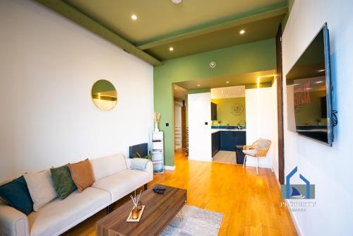 a living room with a couch and a table at Spacious Manchester City Condo - Parking - Next To AO Arena - Local Attraction & Transport Links in Manchester