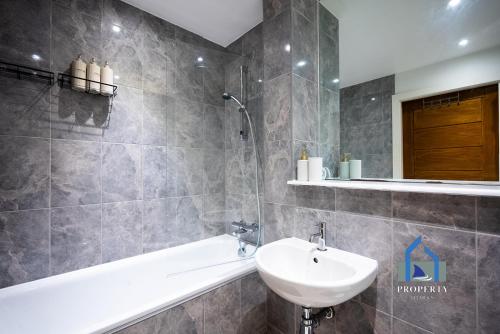 a bathroom with a sink and a toilet and a tub at Spacious Manchester City Condo - Parking - Next To AO Arena - Local Attraction & Transport Links in Manchester