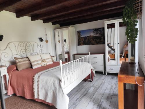 a bedroom with a white bed and a wooden floor at Casa Julián in Garafía