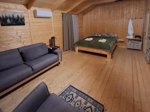 a living room with a couch and a bed at savane mukhranshi in Mukhrani