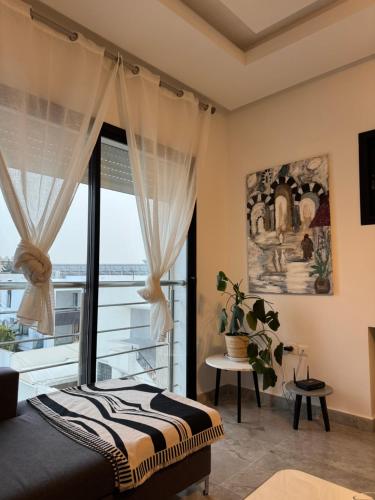 a bedroom with a bed and a large window at La Penélope in Tunis