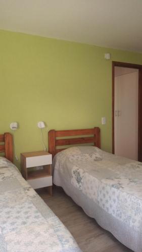 a bedroom with two beds and a table with a lamp at Bosque y Mar in Mar Azul