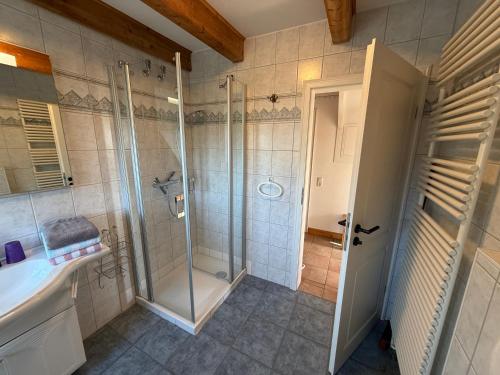 a bathroom with a shower and a sink at Sütjers Hüs in Norddorf