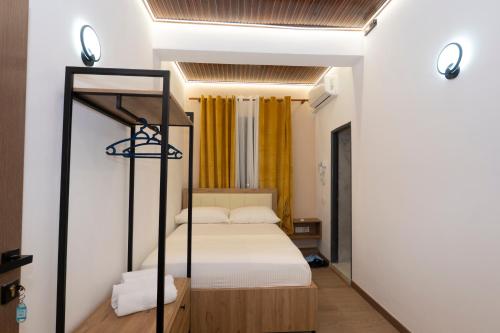 a bedroom with a bunk bed and yellow curtains at Bar Hotel Orgito in Lushnjë