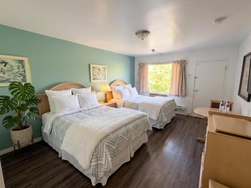 a hotel room with two beds and a window at Persepolis Inn in Niagara Falls