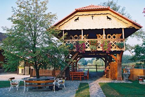 a wooden gazebo with a table and a tree at Cosy Village in Šentjernej