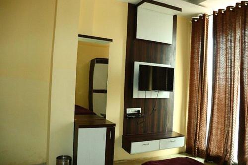 a room with a mirror and a television in a room at Harsh-Regency in Rānchī
