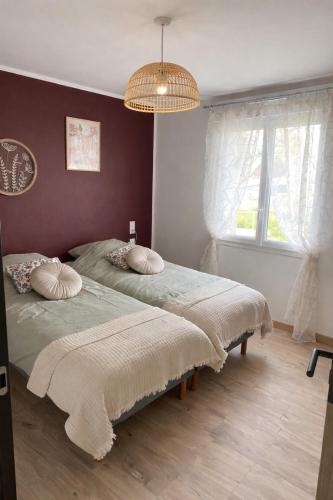 a bedroom with two beds and a chandelier at La Campagnarde in Pargny