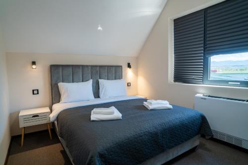 a bedroom with a bed with two towels on it at SEE YOU Apartments in Niš