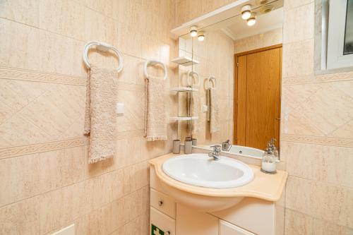 a bathroom with a sink and a mirror at Meia Praia Terrace in Lagos