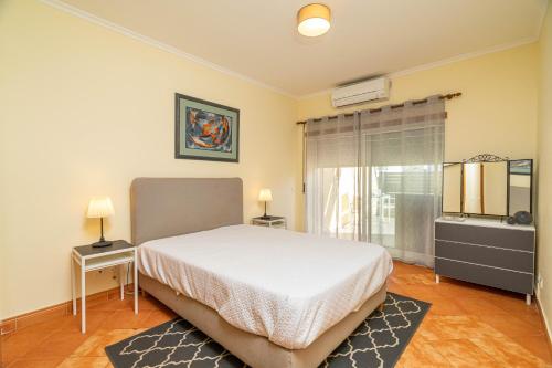 a bedroom with a white bed and a window at Meia Praia Terrace in Lagos
