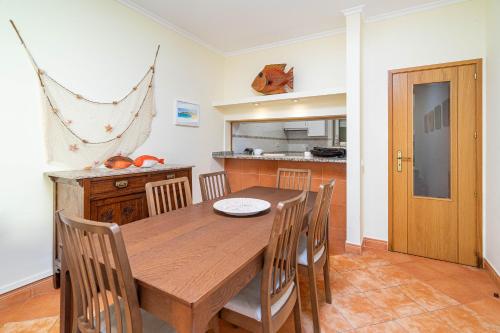 a dining room with a wooden table and chairs at Meia Praia Terrace in Lagos