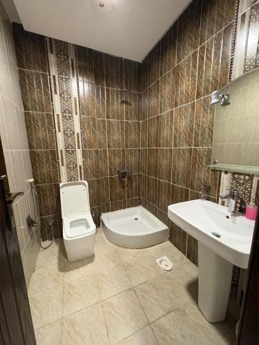 a bathroom with a toilet and a sink at Talya Apartment in Mecca