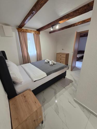 a bedroom with a large bed and a wooden table at Sunrise Skadar lake in Braćeni