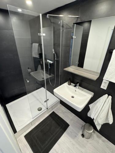 a bathroom with a glass shower and a sink at Bella Vita Apartment due in Ediger-Eller