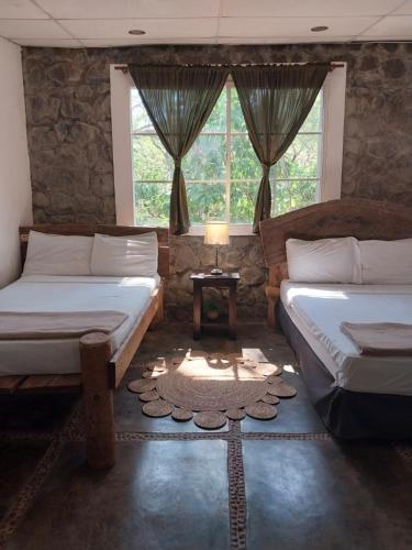 a bedroom with two beds and a window at Atlakamani Surf in Chirilagua