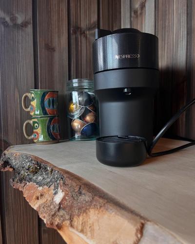 a camera sitting on a wooden table next to a cup at Ravn in Vistad