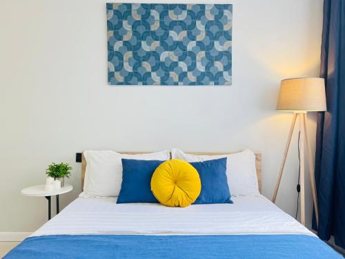 a bed with blue and white pillows and a yellow pillow at 417I2 Gray and Yellow apartment Sholpan city in Almaty