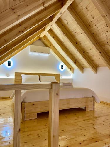 a bedroom in a attic with a bed and a desk at Rosea LOFT in Përmet