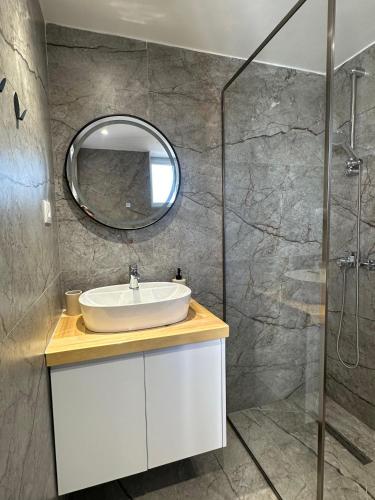 a bathroom with a sink and a mirror at Rosea LOFT in Përmet