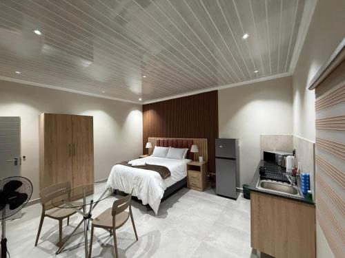 a bedroom with a bed and a table and a kitchen at Mehraz Guesthouse in Piet Retief