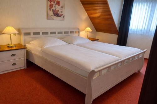 a large white bed in a bedroom with two lamps at Ferienhaus Knecht in Neef