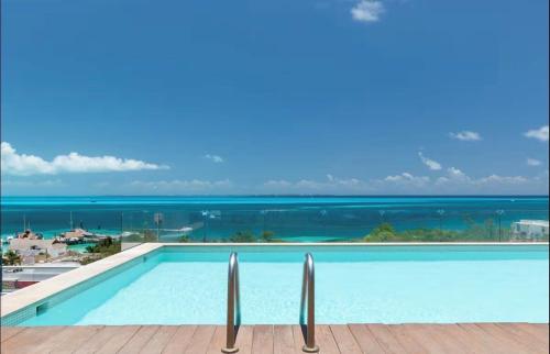 a swimming pool with a view of the ocean at Beautiful sea view apartment in the Hotel Zone Cancun in Cancún