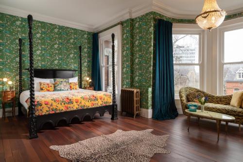a bedroom with a canopy bed and green wallpaper at The Harrison Chambers of Distinction in Belfast