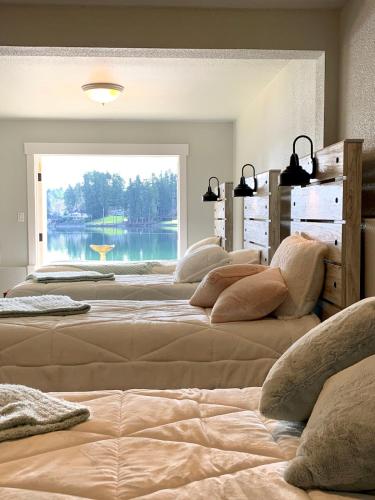 a group of beds in a room with a large window at The Riptide Retreat in Shelton
