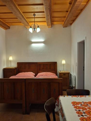 a bedroom with a wooden bed and two tables at Dům u Giordanu in Slavonice