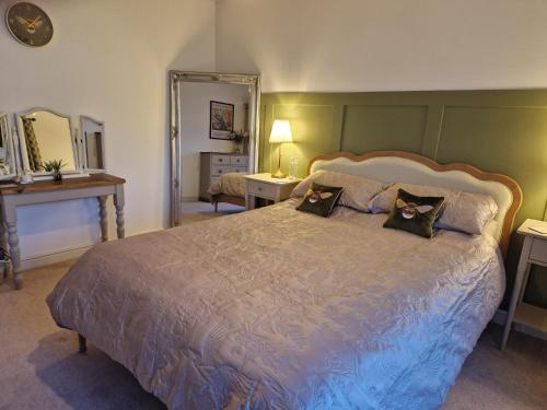 a bedroom with a large bed with two pillows on it at Honeybee Hideaway in Brompton