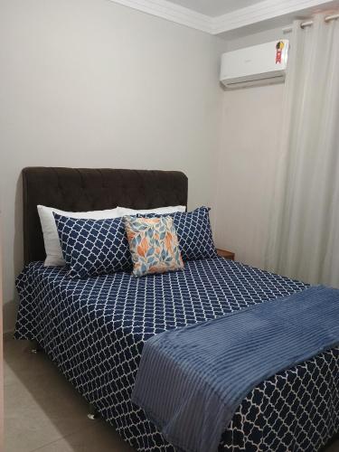 a bed with blue sheets and pillows in a bedroom at Casa Bella in Catanduva