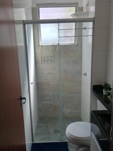 a bathroom with a shower with a toilet and a window at Casa Bella in Catanduva