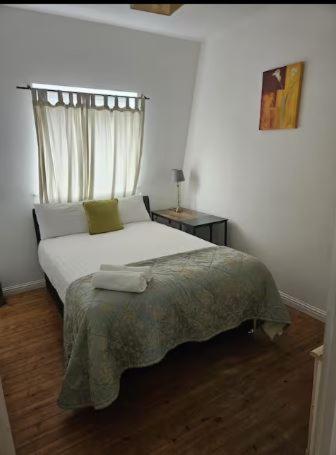 a white bedroom with a bed with a window at Claddagh Retreat in Galway