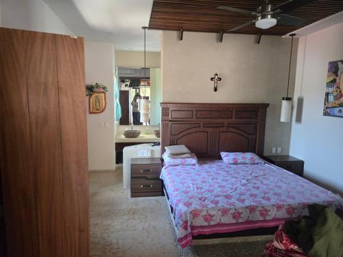 a bedroom with a bed and a cross on the wall at Condominio Dario 12 in Zihuatanejo