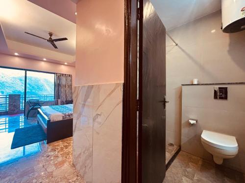 a bathroom with a toilet and a bedroom at Most Awarded Property In Mussoorie in Mussoorie