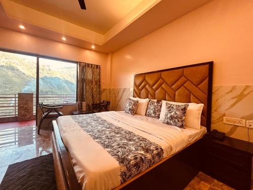 a bedroom with a large bed and a large window at Most Awarded Property In Mussoorie in Mussoorie