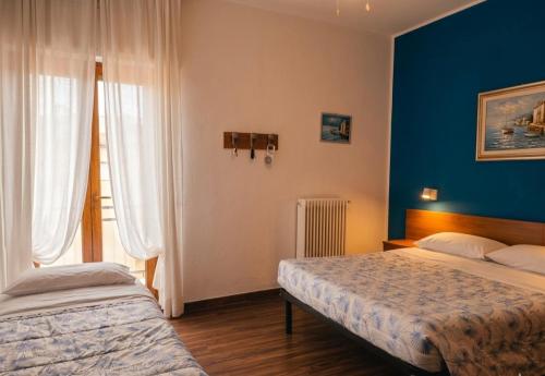 a bedroom with two beds and a blue wall at Hotel Luisa in Brenzone sul Garda