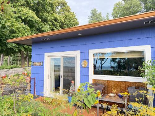 a blue tiny house with a table in a garden at Blū House in Williamsburg