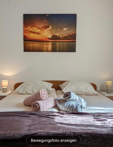 a bed with towels on it with a painting on the wall at Međugorje Quit Hideaway in Botići