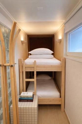 a small bedroom with a bunk bed and a window at Acmé Appartement 200 m du lac d'Annecy in Angon