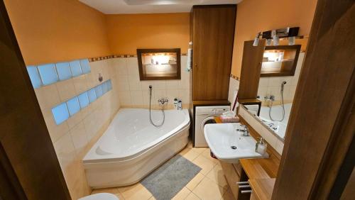 a bathroom with a tub and a toilet and a sink at Mézi Lazy in Gyenesdiás