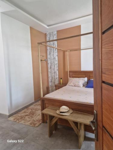 a bedroom with a bed and a table with a hat on it at Villa Aria in Mbour