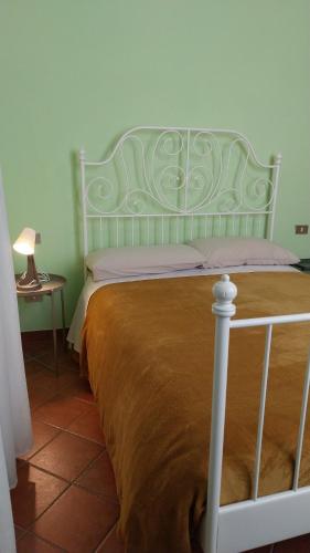 a bed with a green headboard in a bedroom at Tenuta Rio del Sole-Camera doppia in Albairate