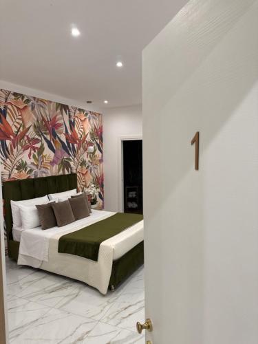 a bedroom with a large bed with a colorful wall at Savior Deluxe Rooms in Naples