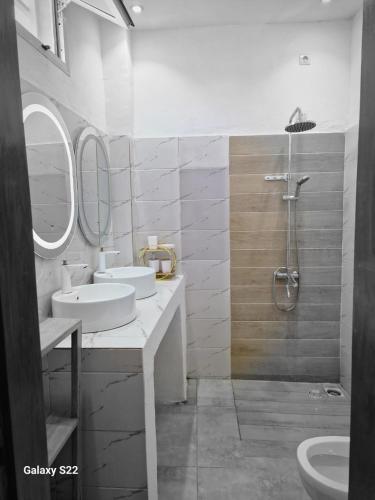 a bathroom with two sinks and a shower at Villa Aria in Mbour