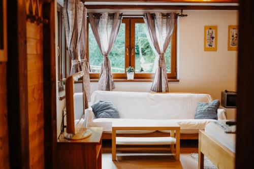 a living room with a white couch and a window at Chata Mir in Dolní Bečva