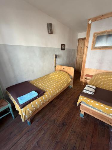 two beds in a room with wooden floors at File dans ta chambre ! in Le Monastier sur Gazeille