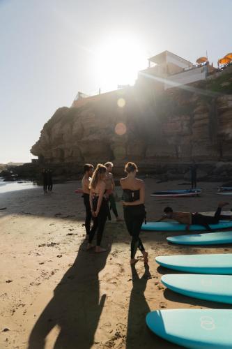 a group of people standing on a beach with surfboards at Flooka Surf Yoga in Imsouane